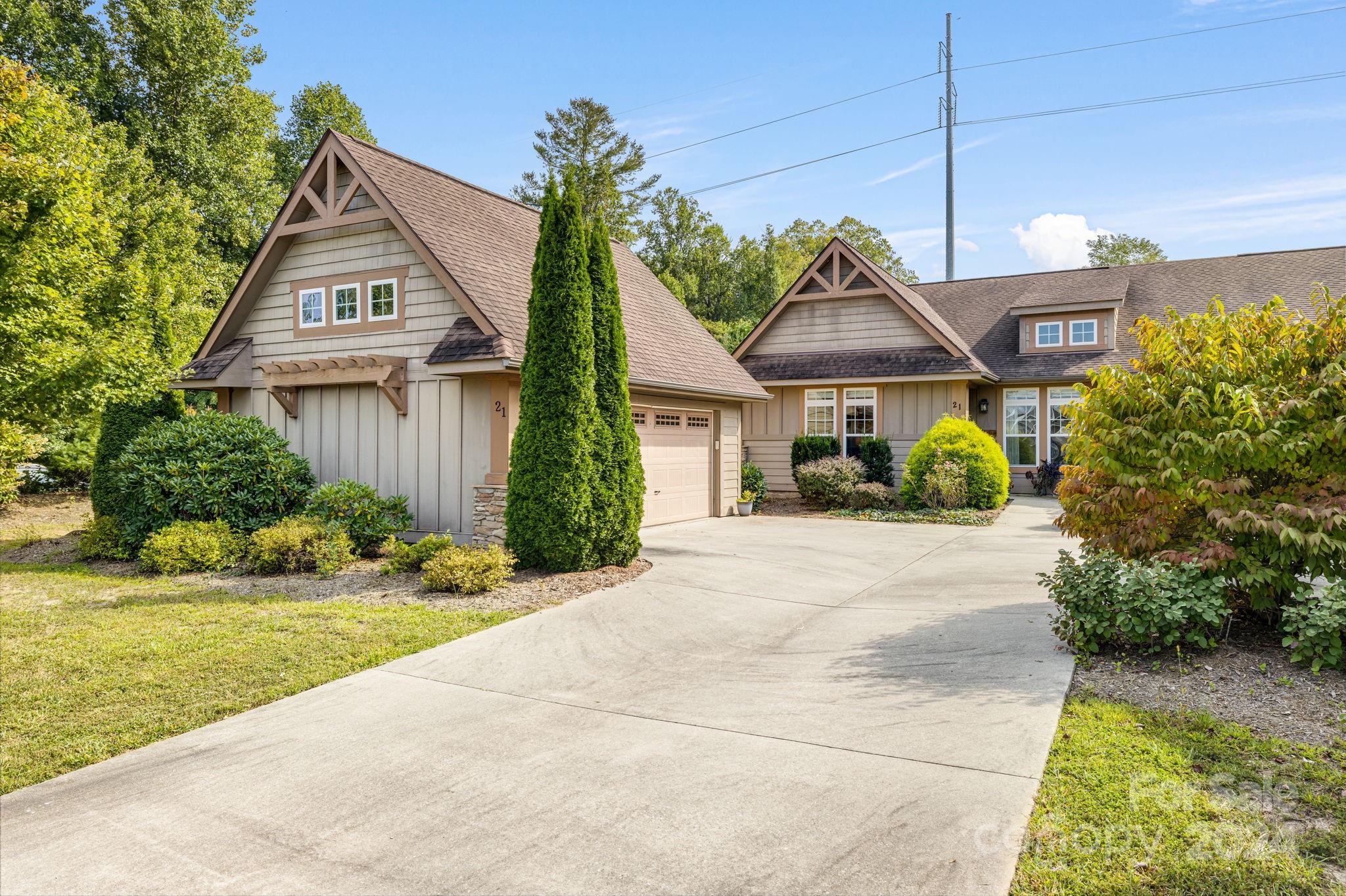 a front view of a house with a yard and potted plants