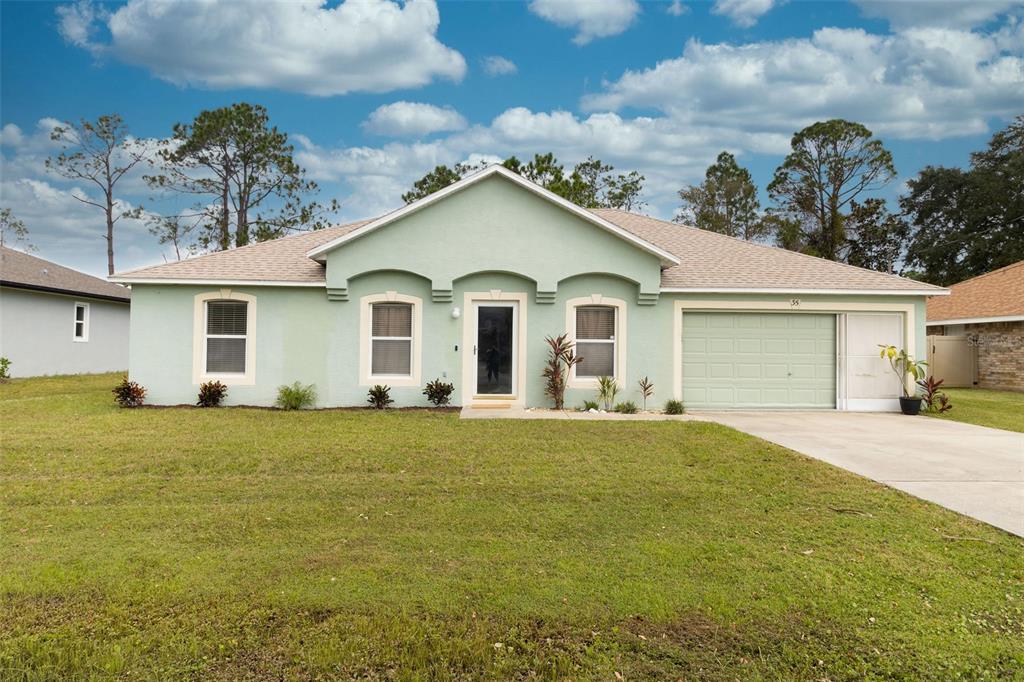 a front view of a house with a garden and yard