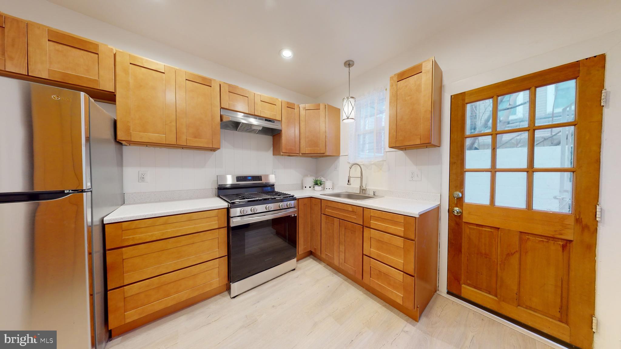 a kitchen with stainless steel appliances granite countertop a stove a sink and a refrigerator