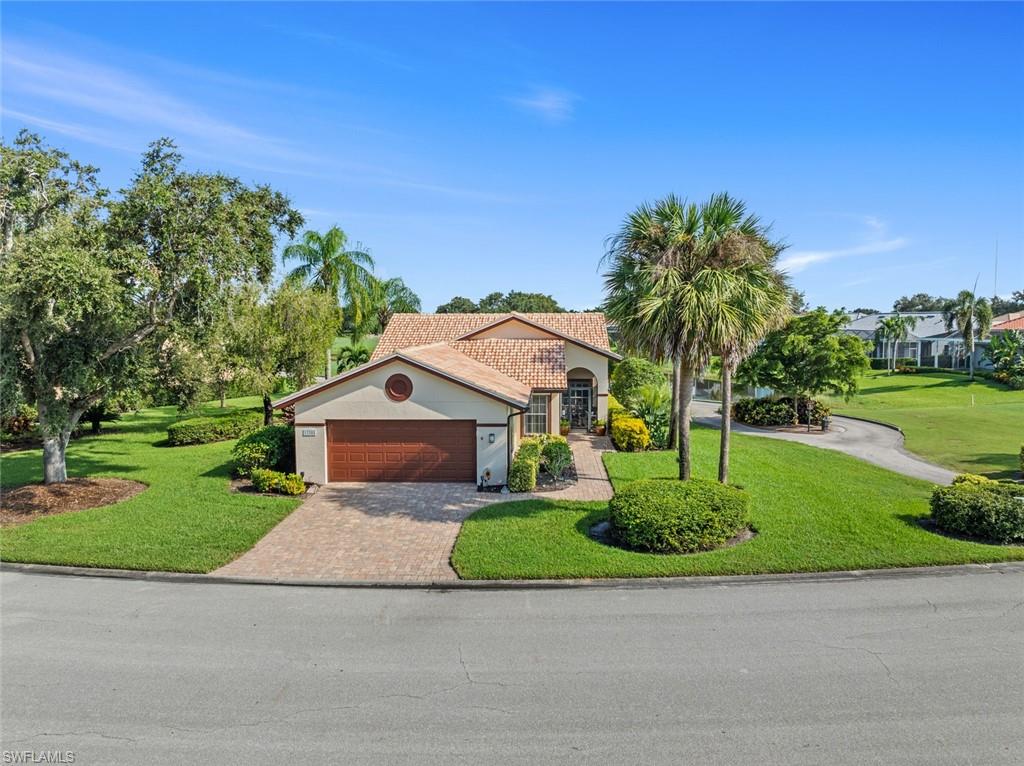 View of front of property featuring a garage and a front lawn