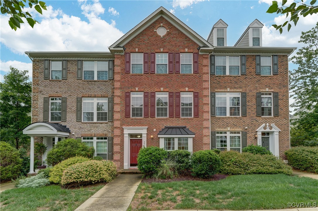 front view of a brick house with a yard