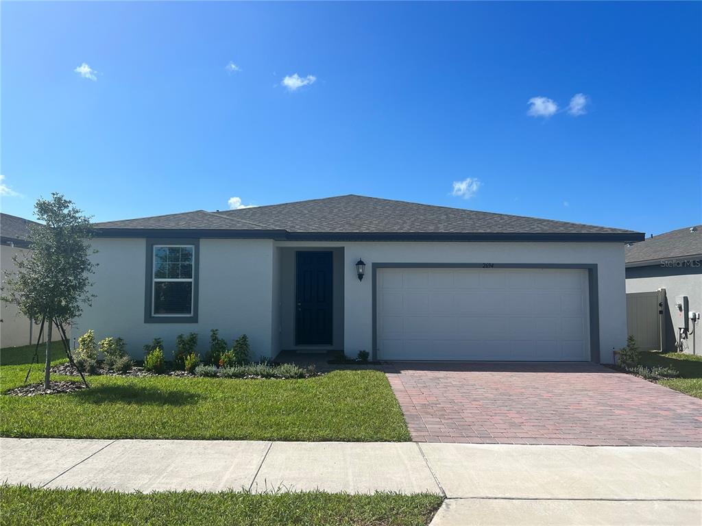 a front view of a house with a yard and garage