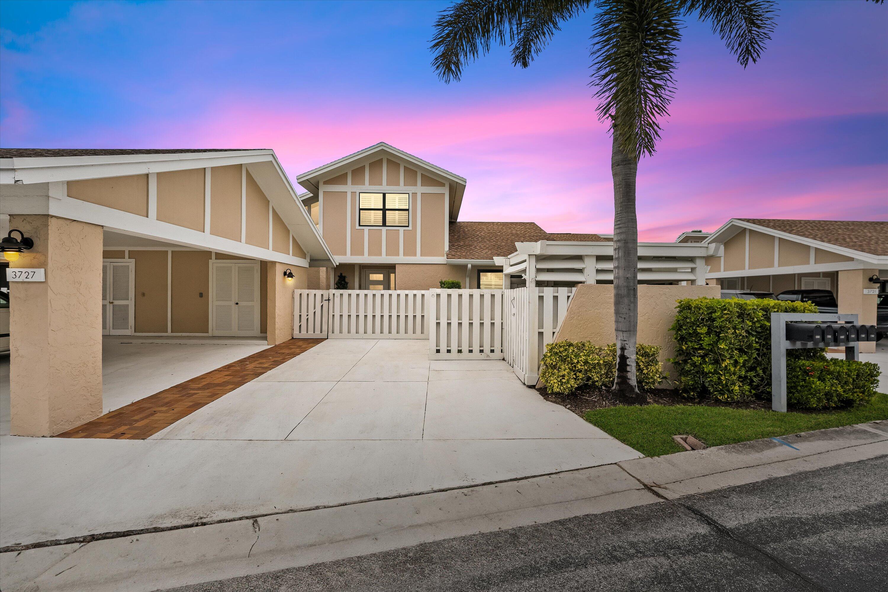 a front view of a house with yard and lake view