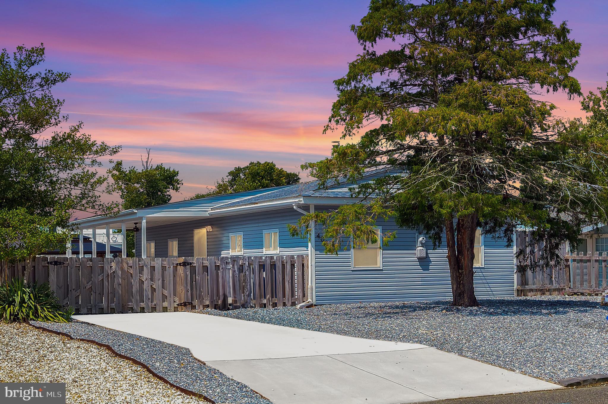 a view of a house with a small yard and wooden fence