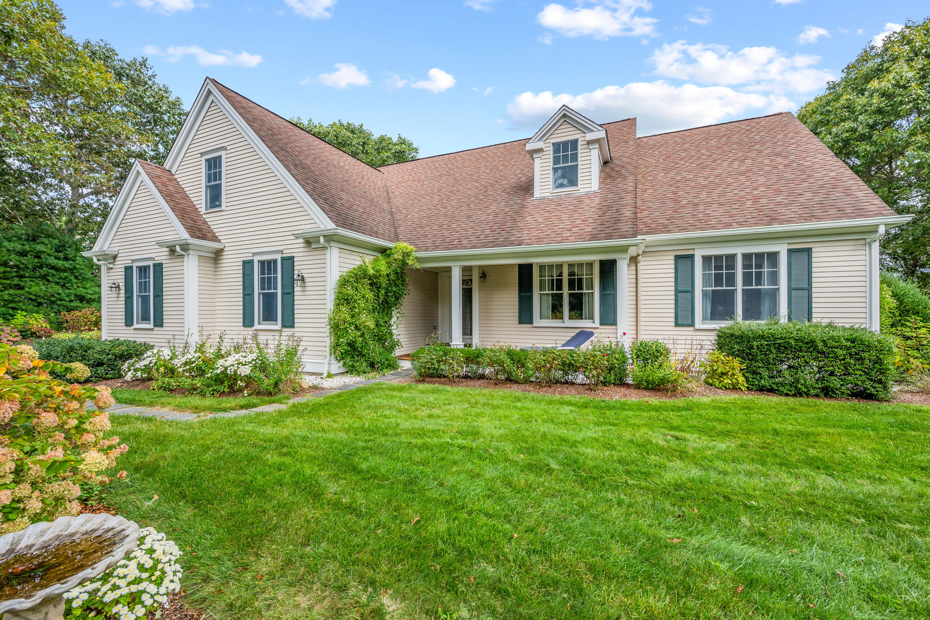 a front view of a house with a yard and potted plants