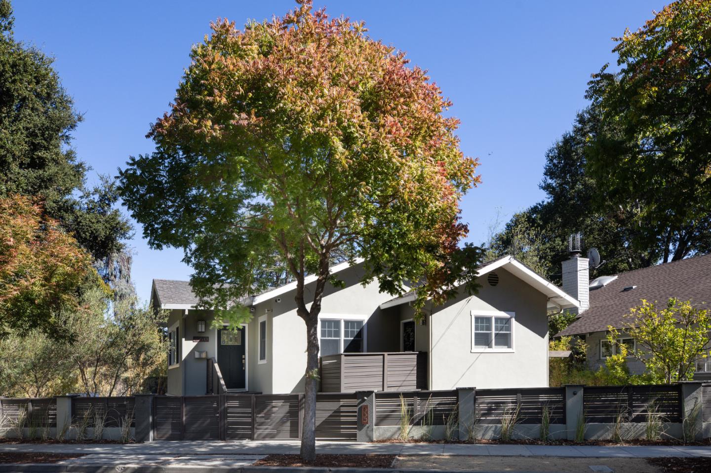 a front view of a house with a tree