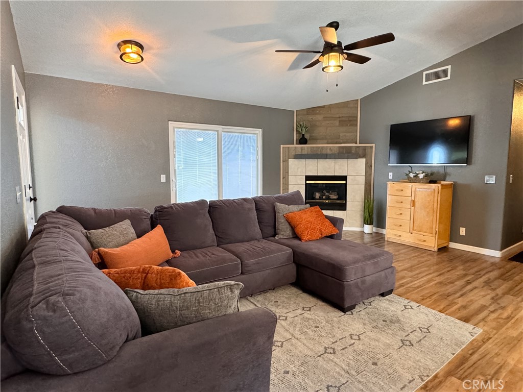 a living room with furniture a flat screen tv and a fireplace