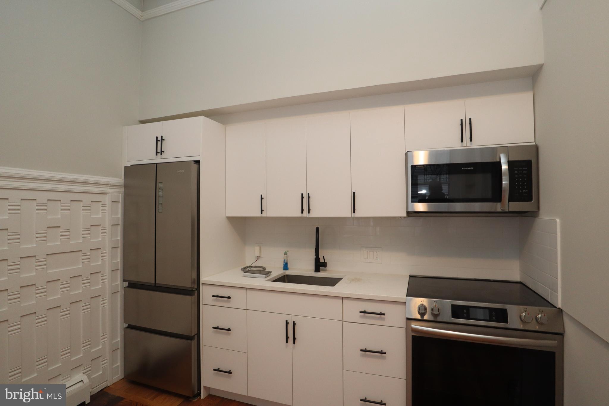 a kitchen with cabinets appliances and a counter space