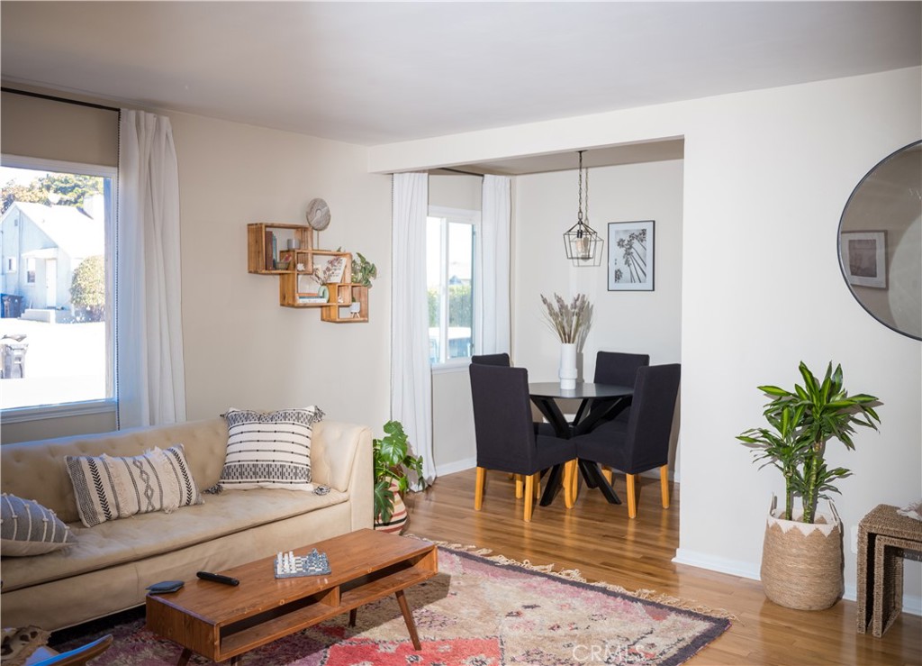 a living room with furniture a dining table and a potted plant