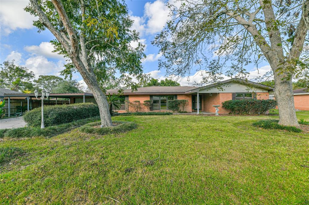 a front view of a house with yard and green space