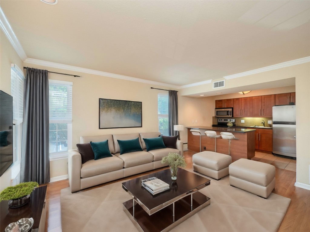 a living room with furniture kitchen view and a window