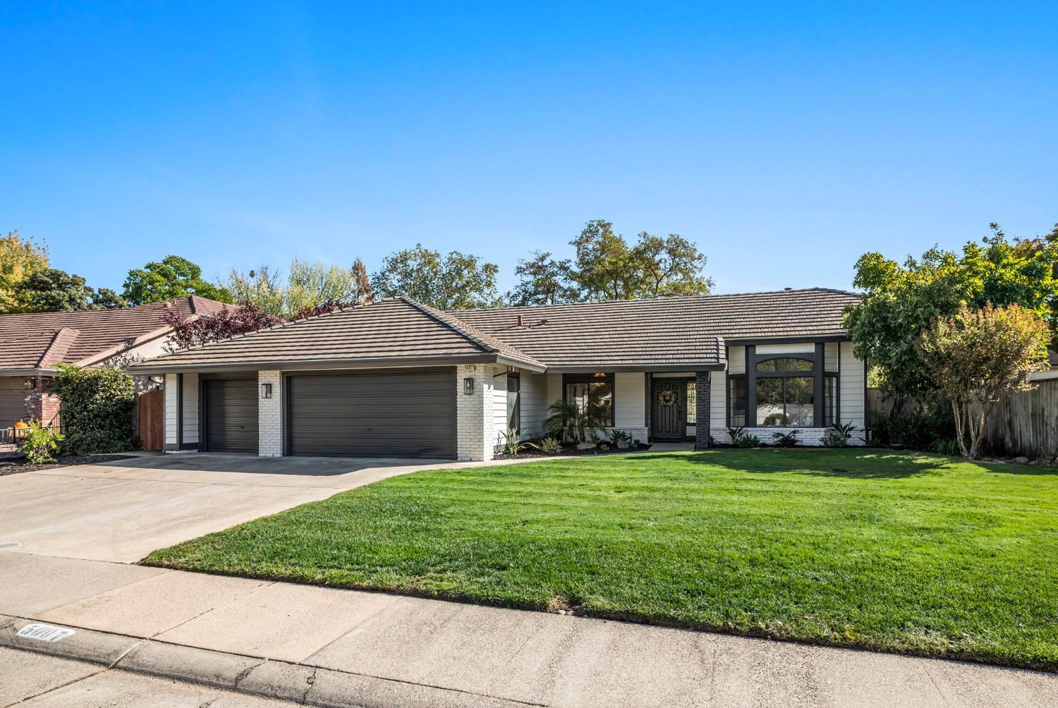 a front view of a house with a yard and trees