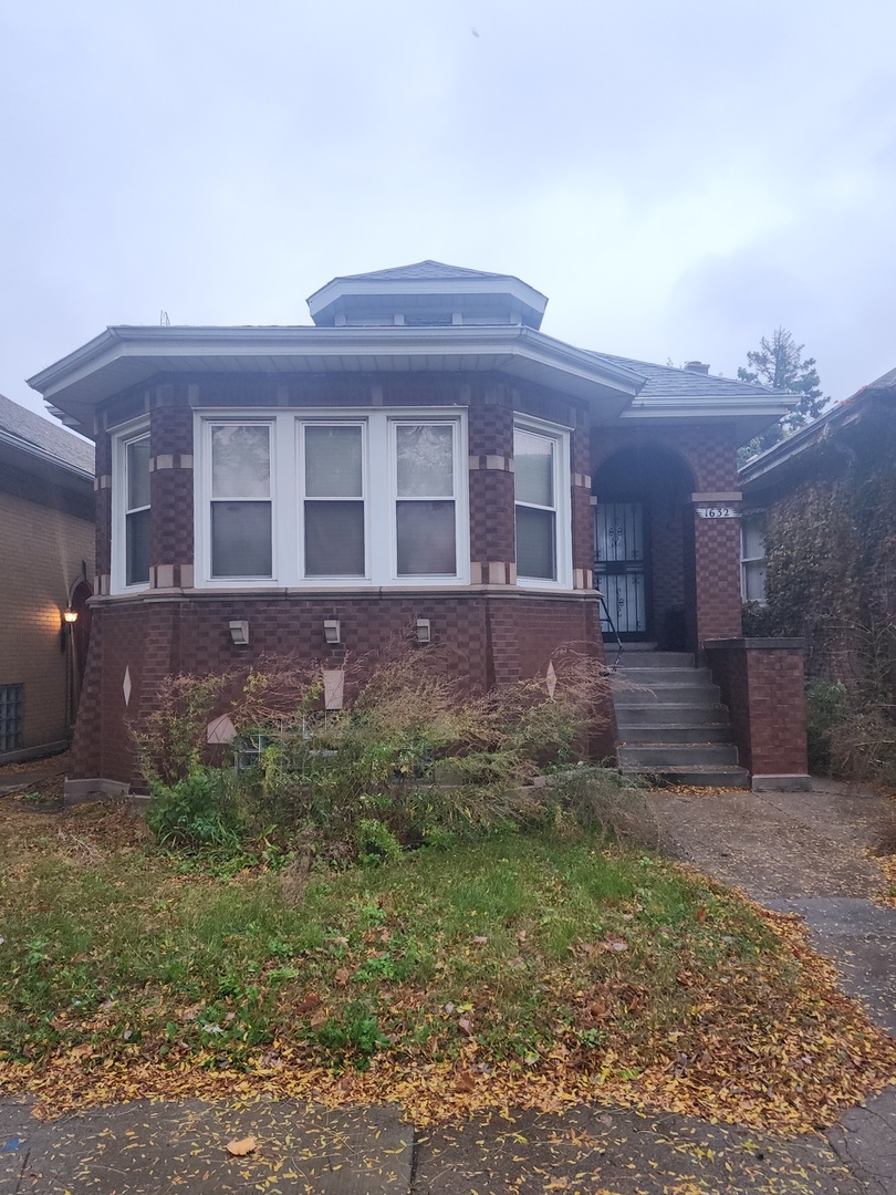 a view of a brick house with a yard