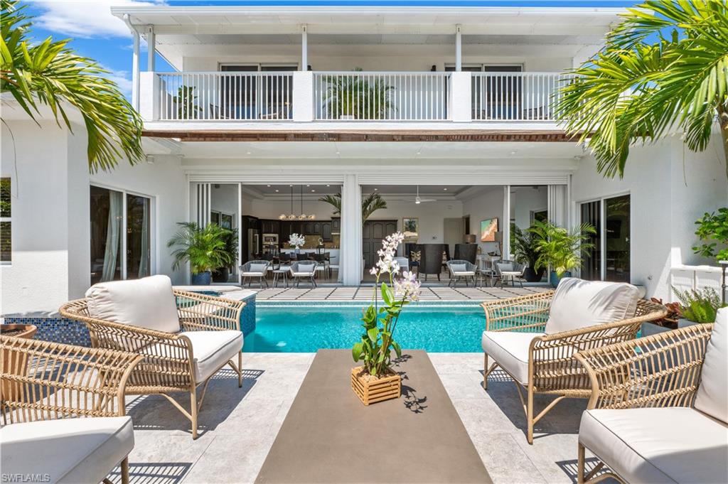 a view of a patio with couches table and chairs and potted plants