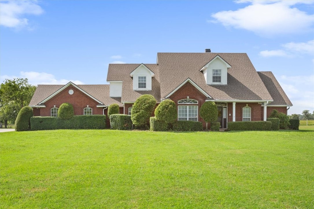 a front view of a house with yard and green space