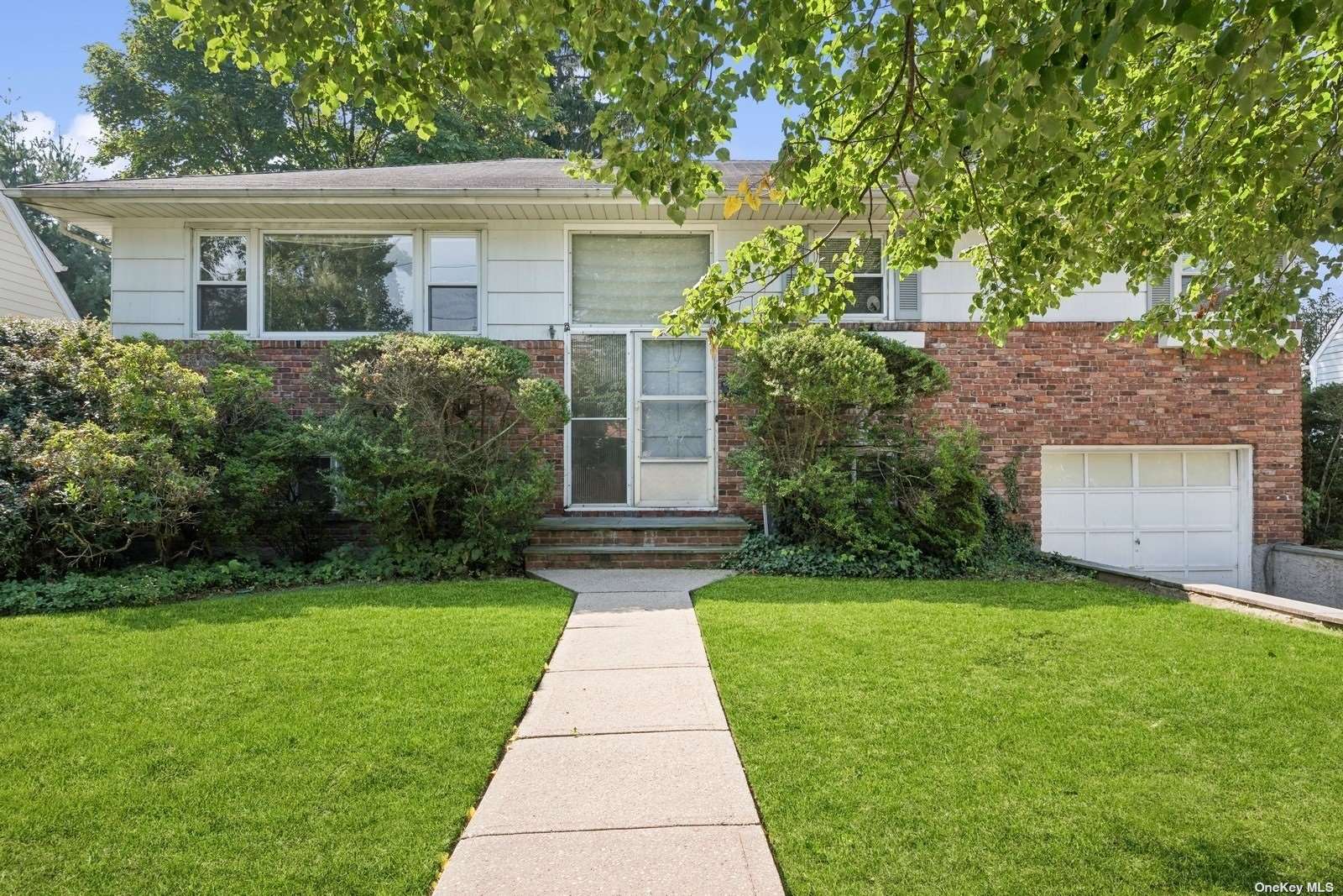 a front view of a house with a yard and trees