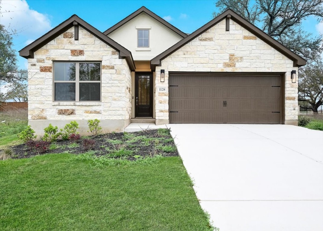 a front view of a house with a yard and garage