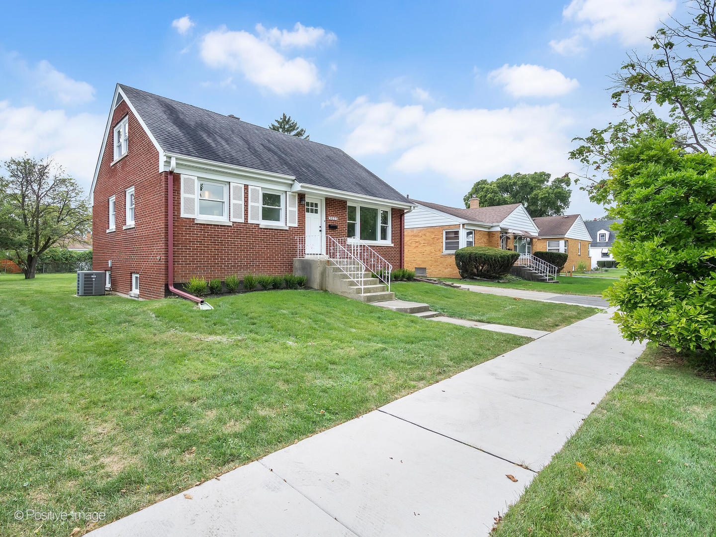 a front view of house with yard and green space