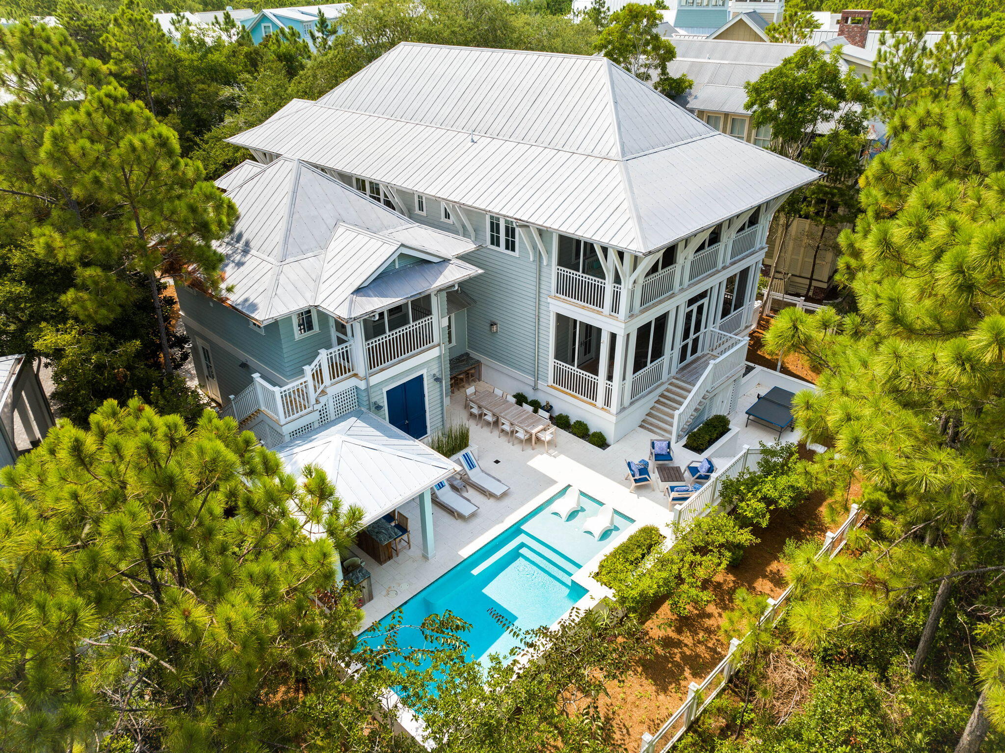 a aerial view of a house with swimming pool and large trees