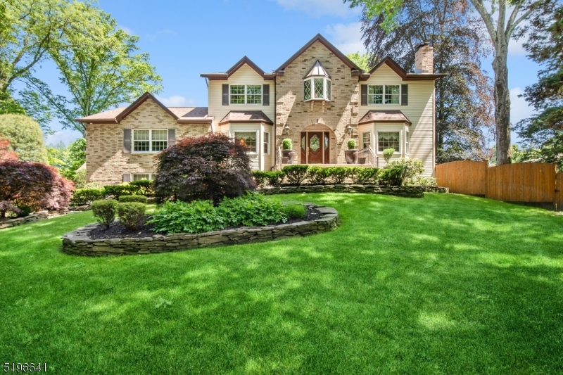 a view of a house with a big yard and large trees