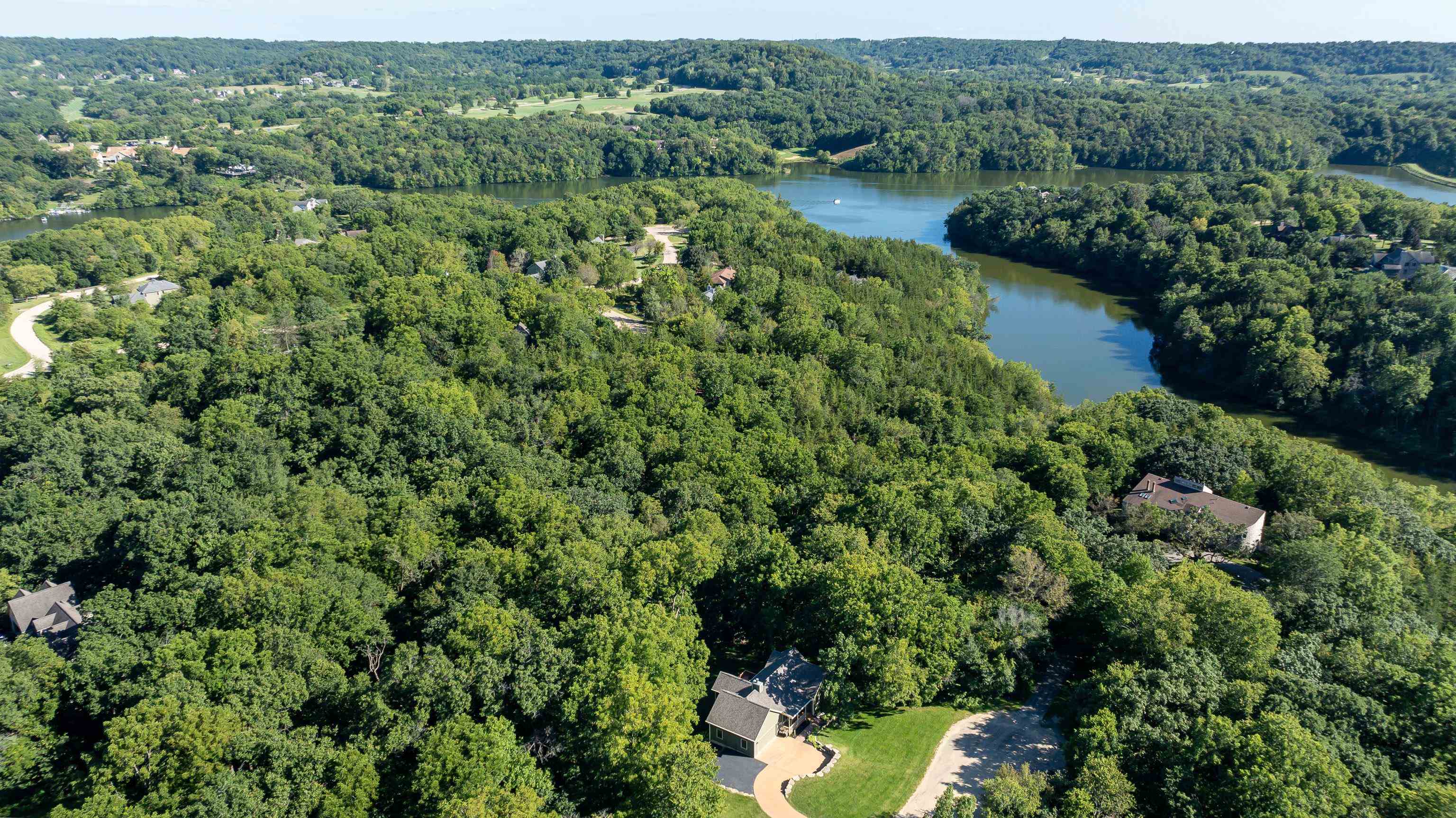 an aerial view of residential houses with outdoor space and trees all around