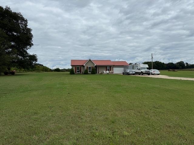 View of front facade featuring a garage and a front yard