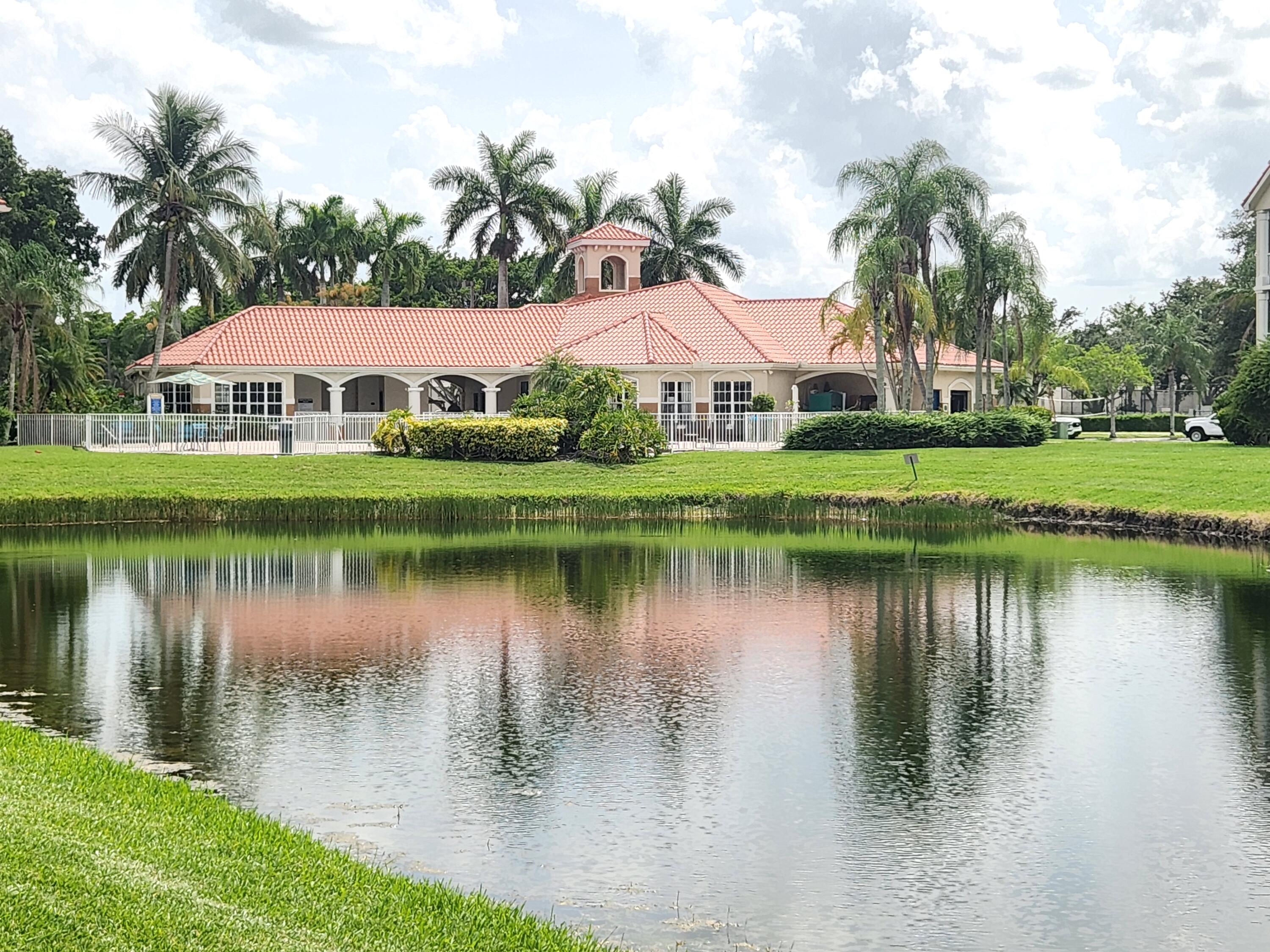 a view of a house with a yard and a pond