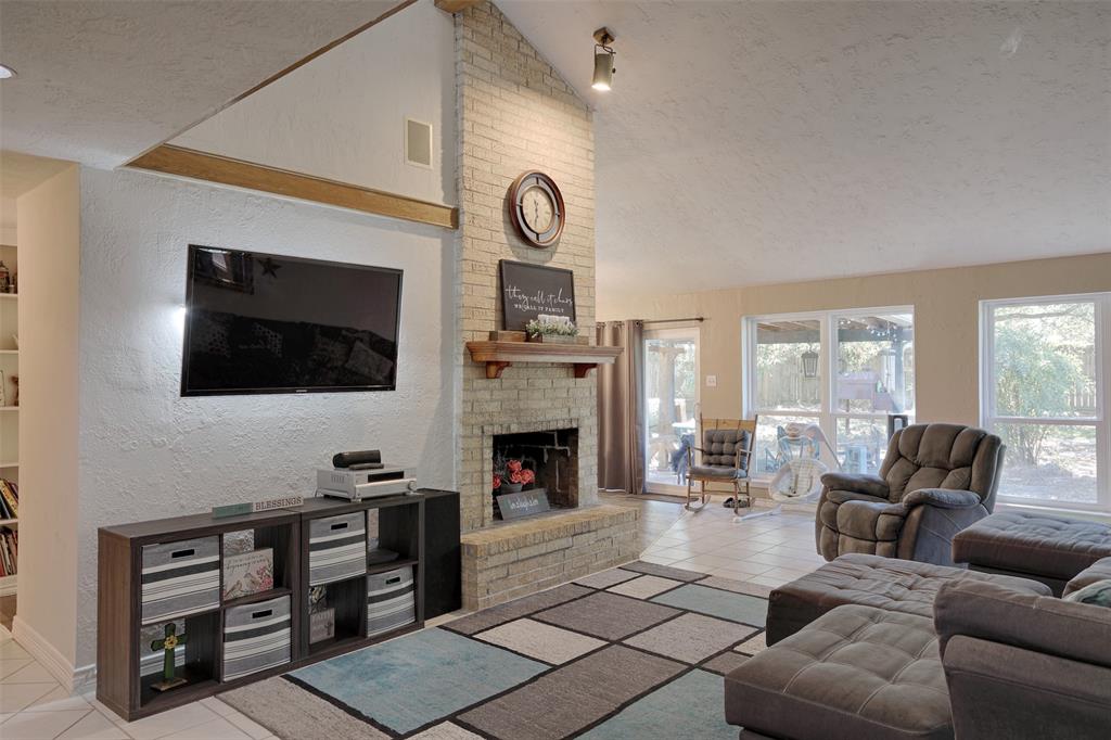 a living room with furniture a flat screen tv and a fireplace