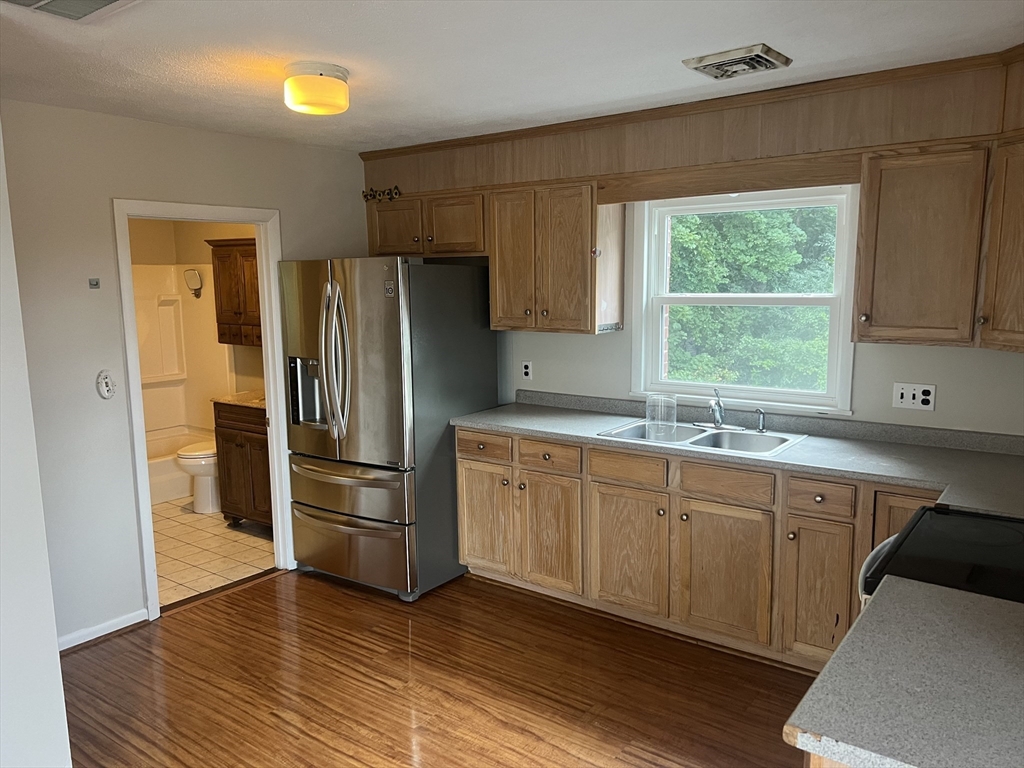 a kitchen with granite countertop a refrigerator and a sink