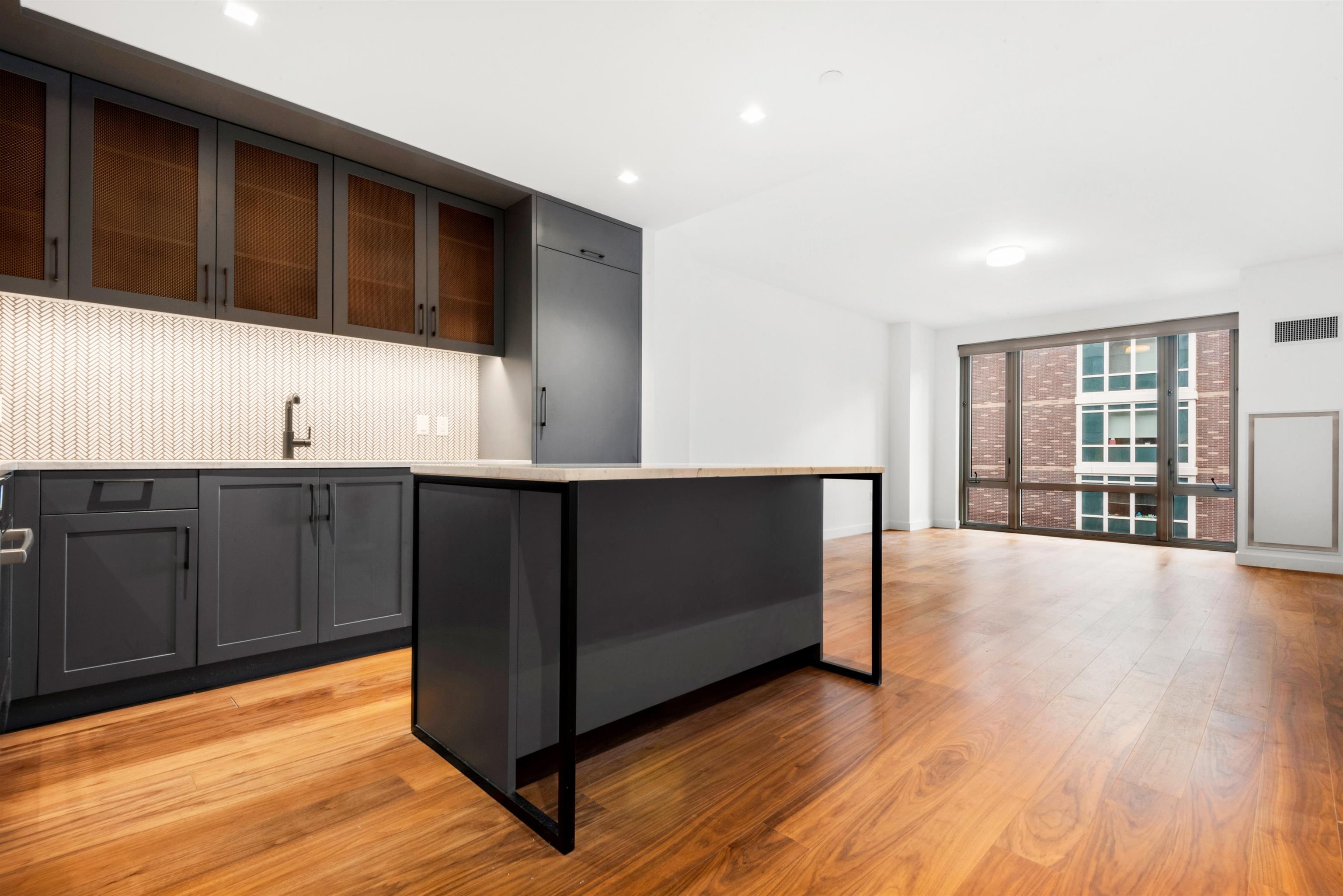 a kitchen with stainless steel appliances granite countertop a sink and cabinets with wooden floor