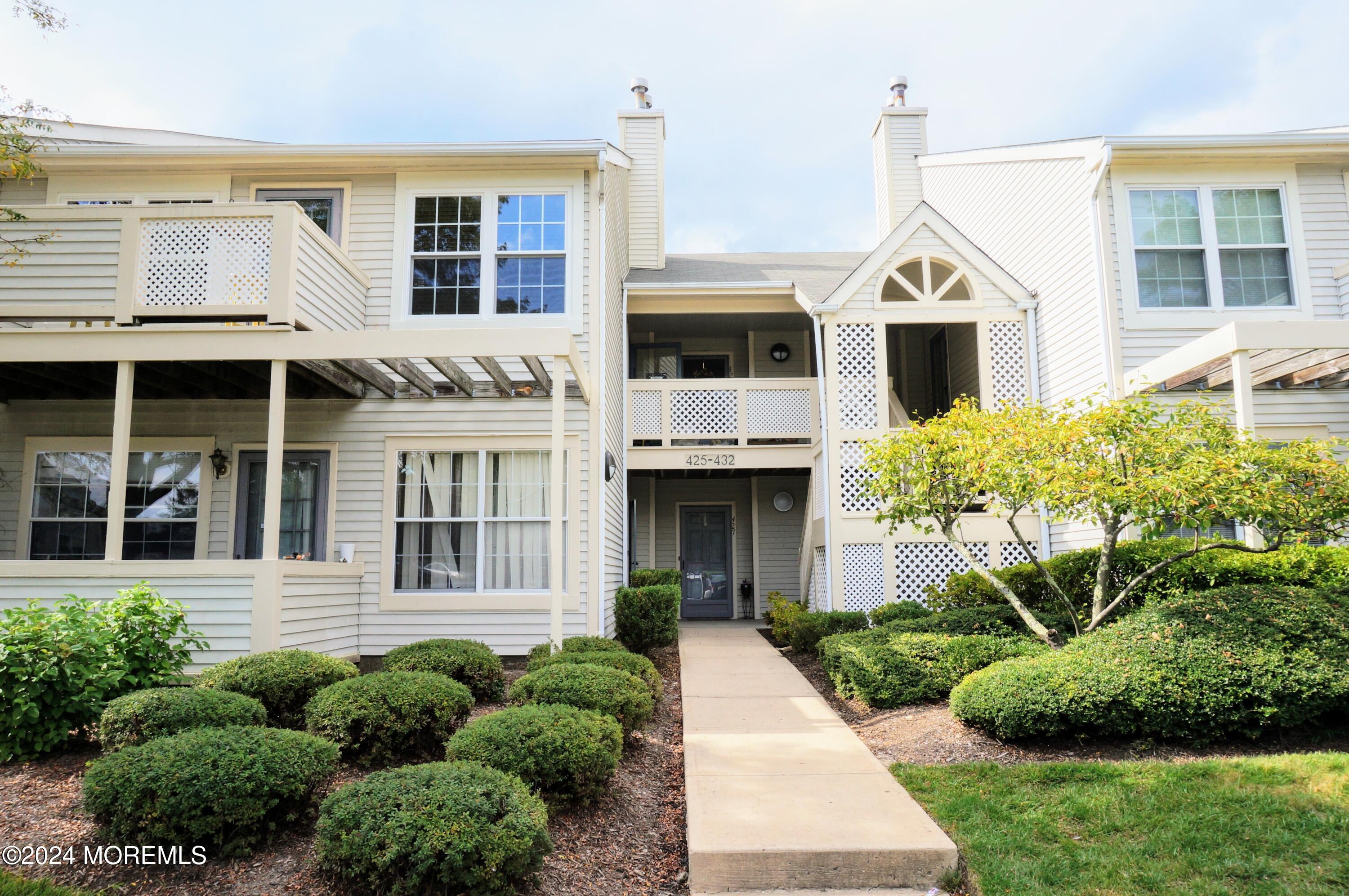 a front view of a house with a yard and potted plants