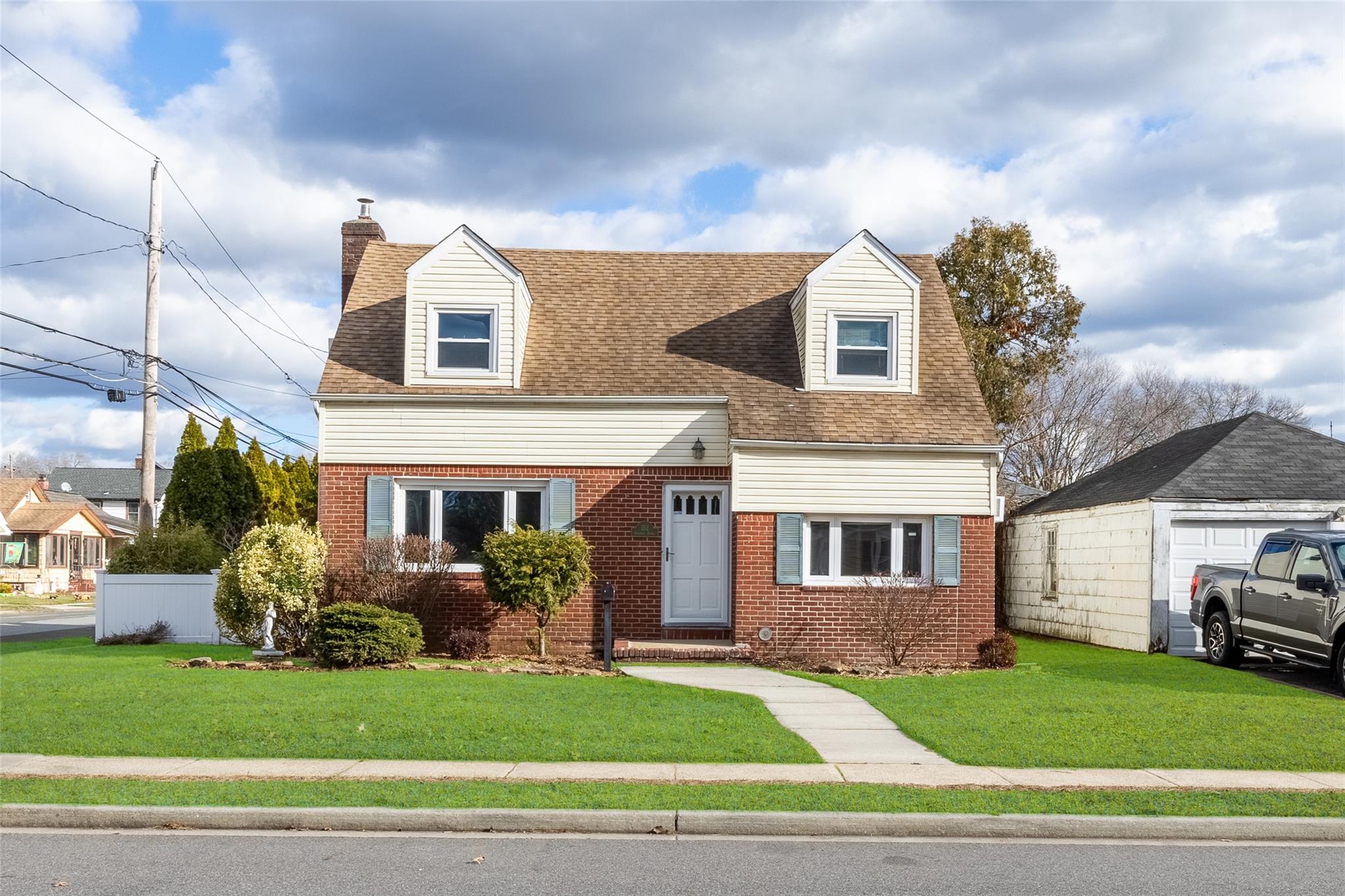 Cape cod house featuring a front lawn