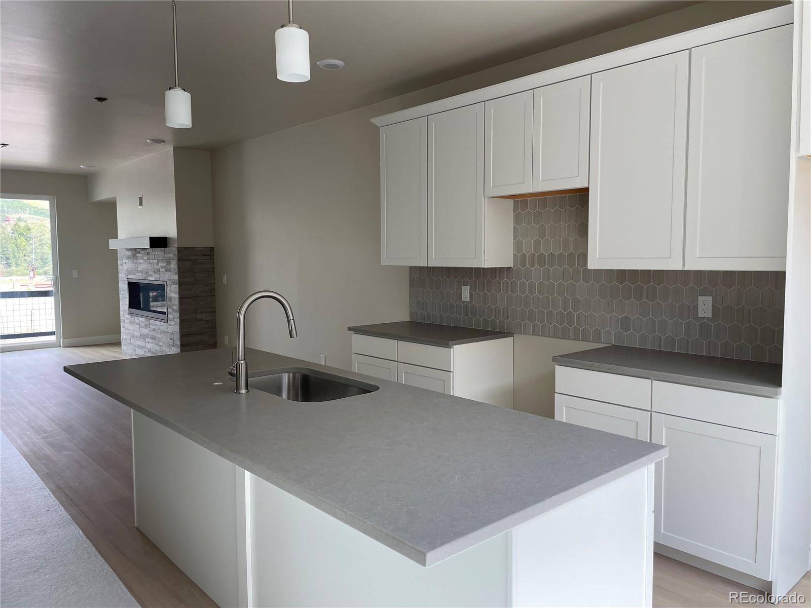 a kitchen with kitchen island a sink a stove and white cabinets