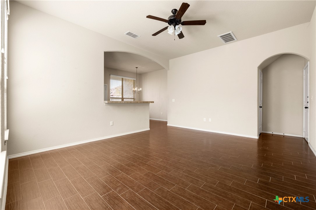 a view of a room with wooden floor and a ceiling fan