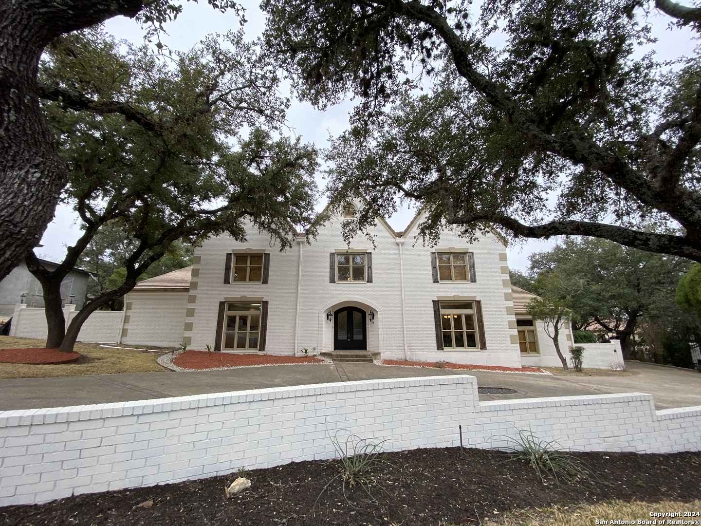 a front view of a house with a tree