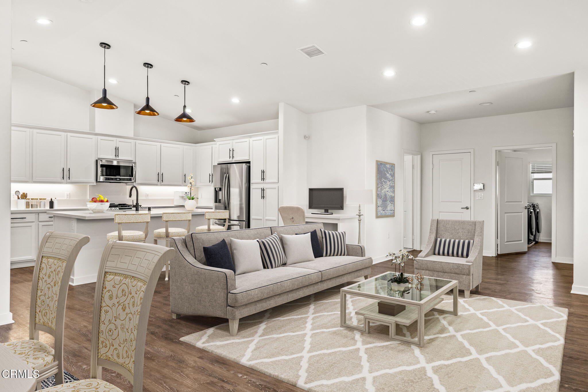 a living room with lots of furniture and view of kitchen