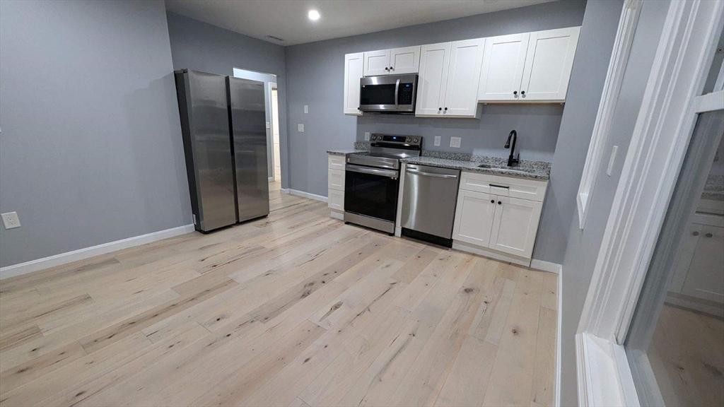 a kitchen with stainless steel appliances a refrigerator sink and microwave