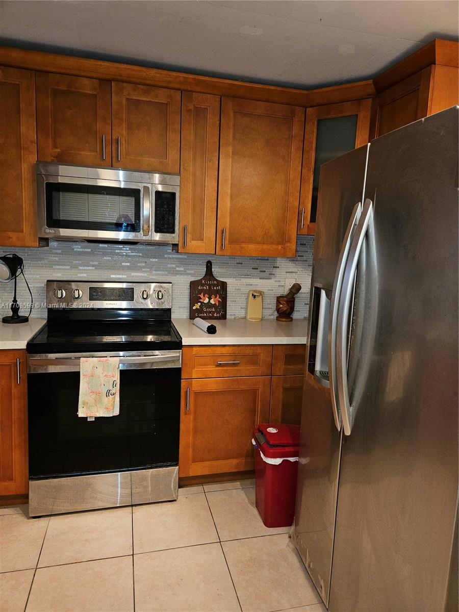 a kitchen with stainless steel appliances a stove a sink and a refrigerator