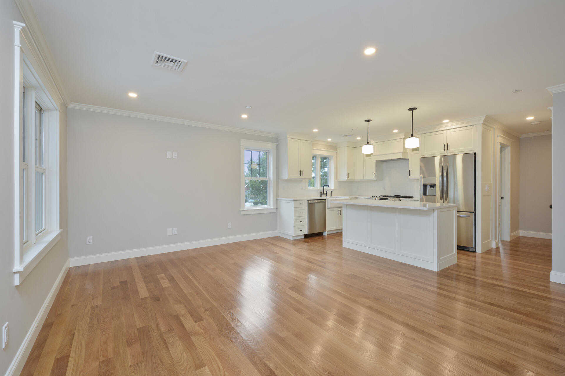 a view of kitchen with kitchen island wooden floors appliances and cabinets