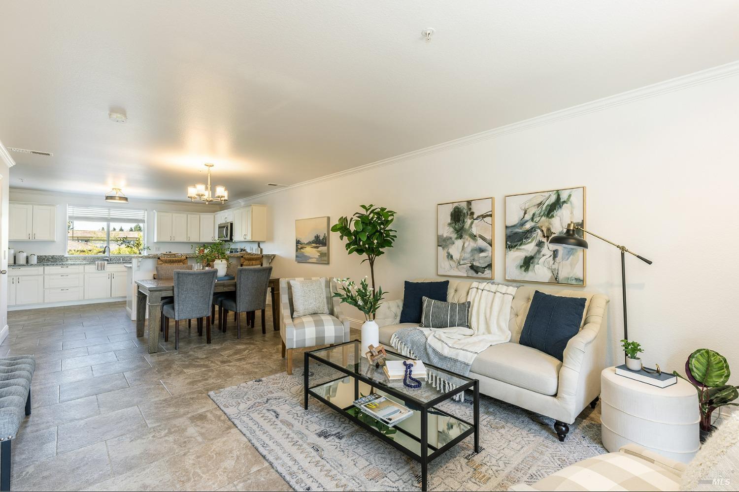 a living room with furniture and a dining table with kitchen view