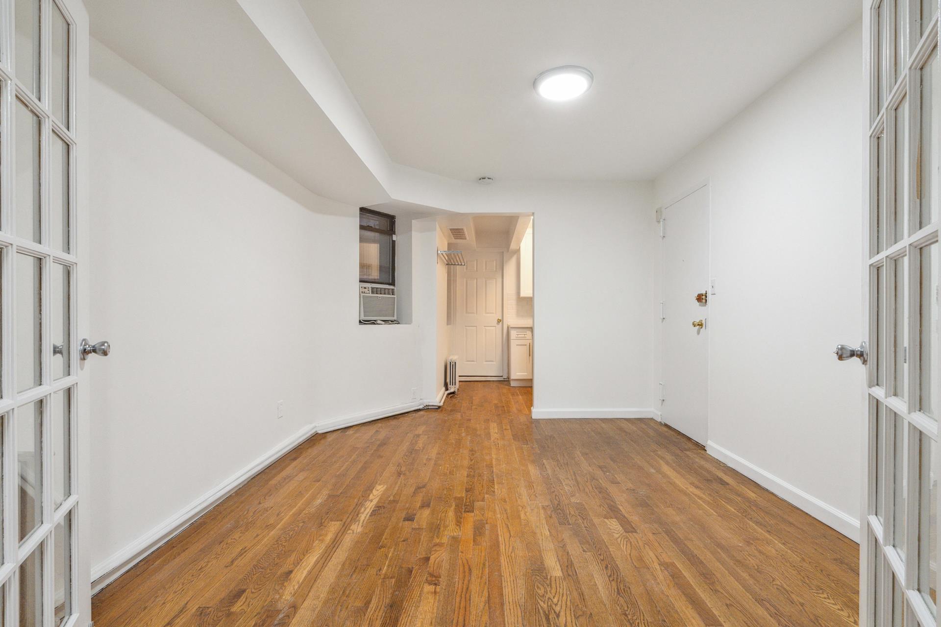 a view of empty room with wooden floor