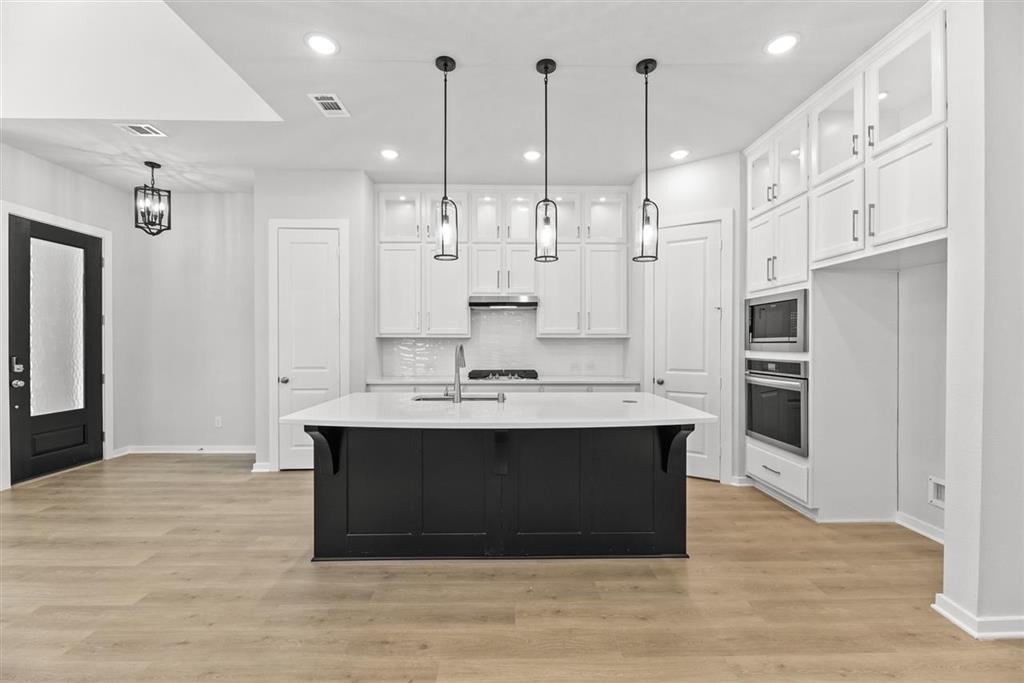 a view of kitchen with stainless steel appliances granite countertop kitchen island sink stove and refrigerator