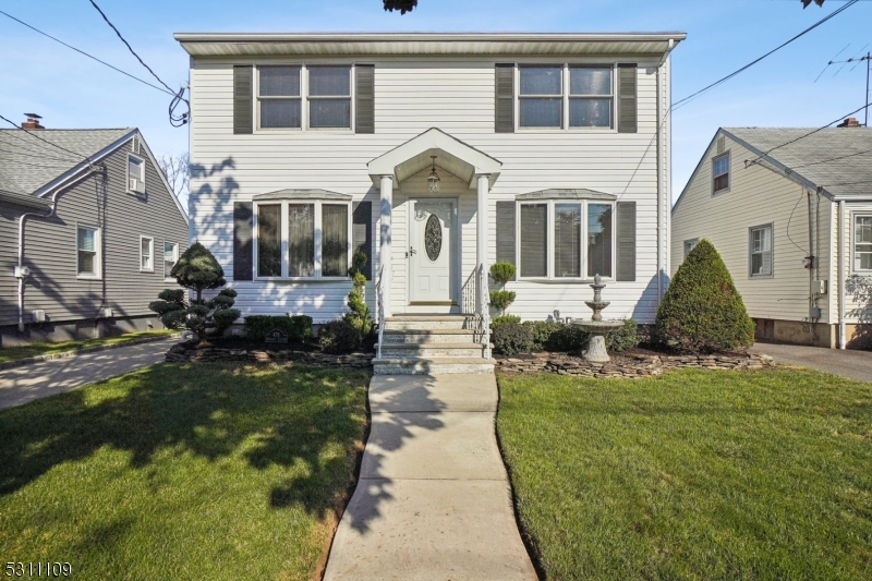 a front view of a house with a garden and plants