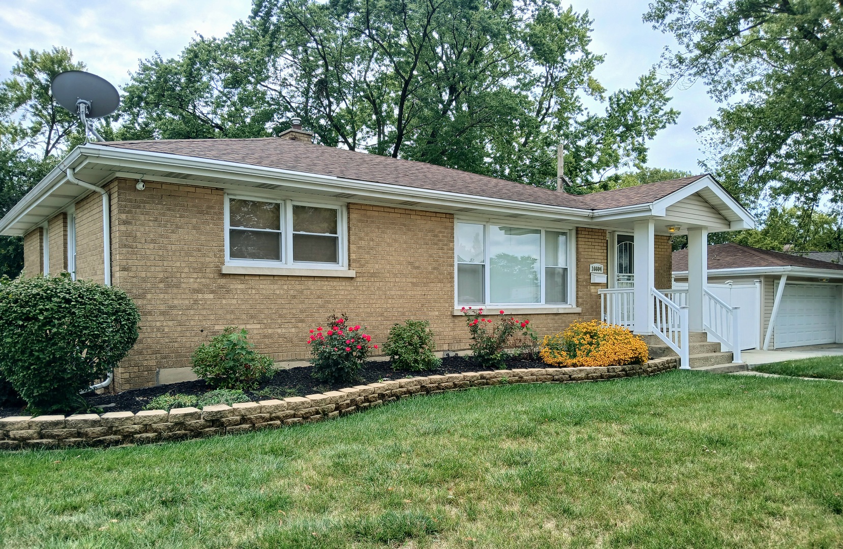 a front view of a house with a garden and plants