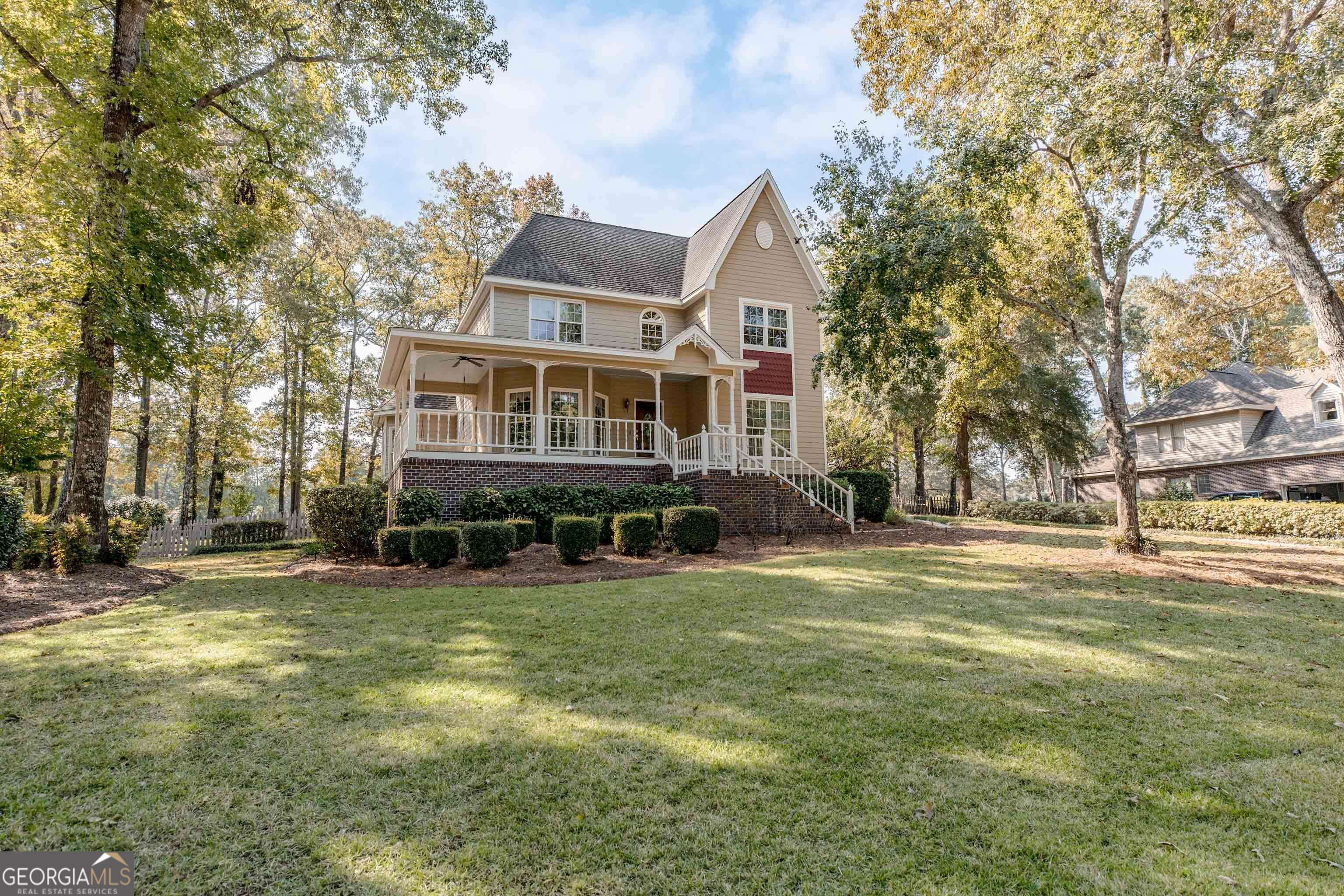 a view of a house with a big yard and large trees