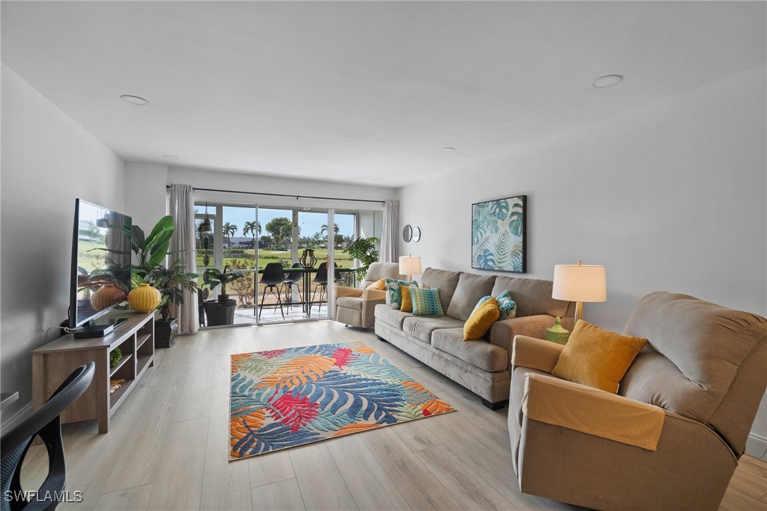 a living room with furniture flat screen tv and a large window