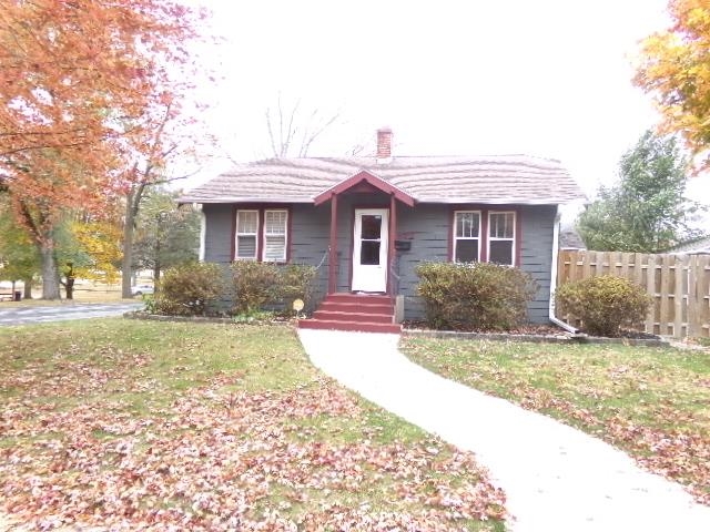 a view of a house with a yard and potted plants