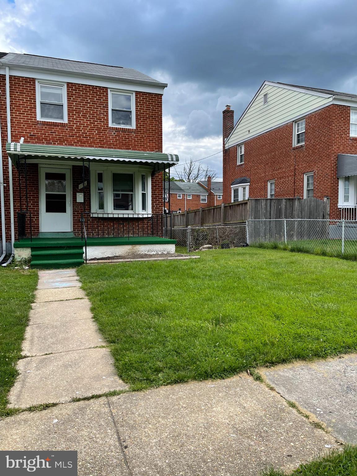 a front view of a brick building with a yard