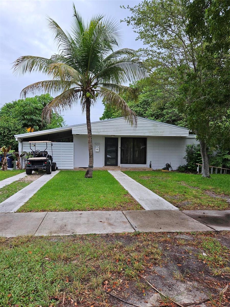 a view of a house with a yard and palm trees