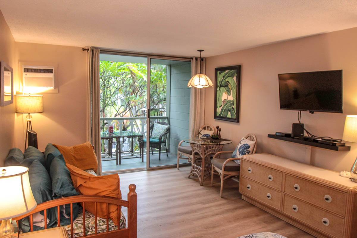 a living room with furniture a flat screen tv and floor to ceiling window